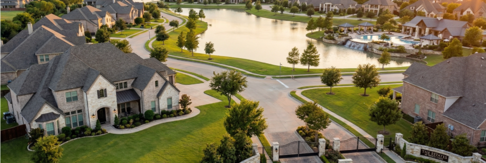 Aerial golden-hour view of a luxury gated community in Frisco, TX with a lake, resort-style pool, and estate homes.